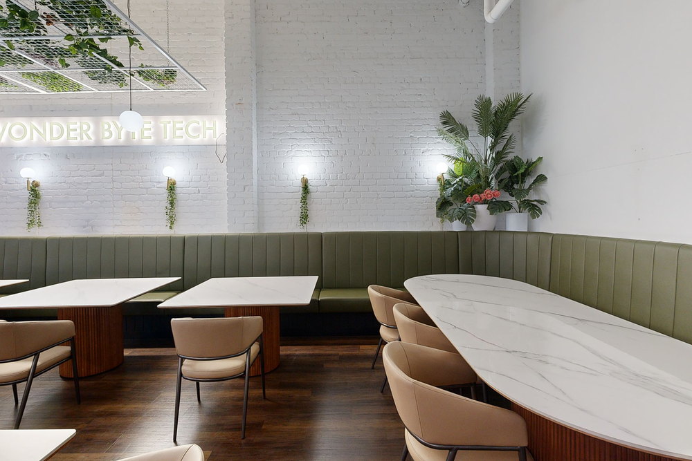The green booths and marble tables along the white brick wall, as captured